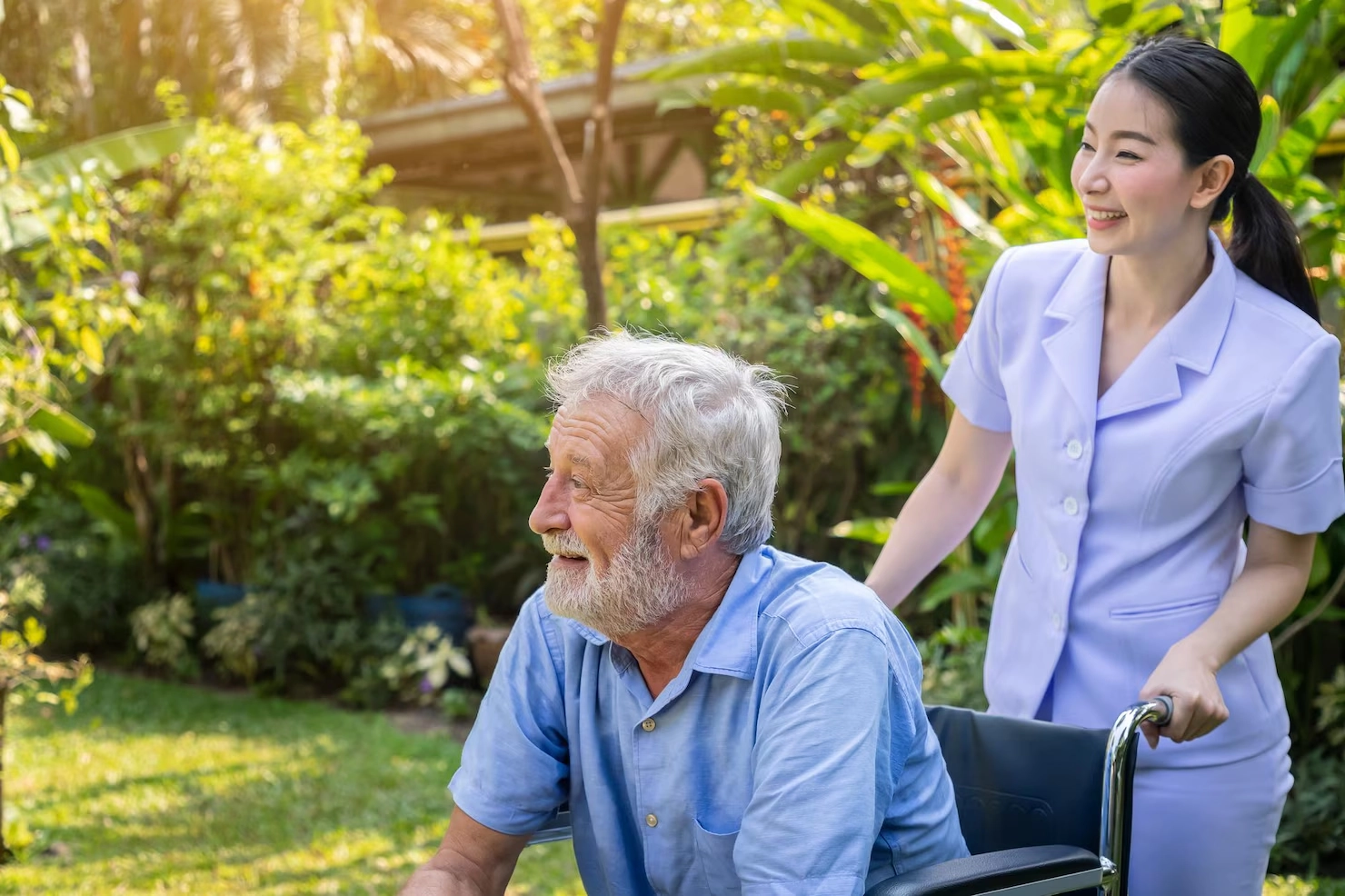 nurse standing beside an elderly woman smiling